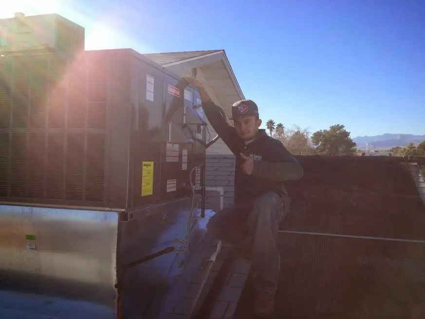 HVAC technician performing AC Tune-Up on a rooftop unit in Cameron Park